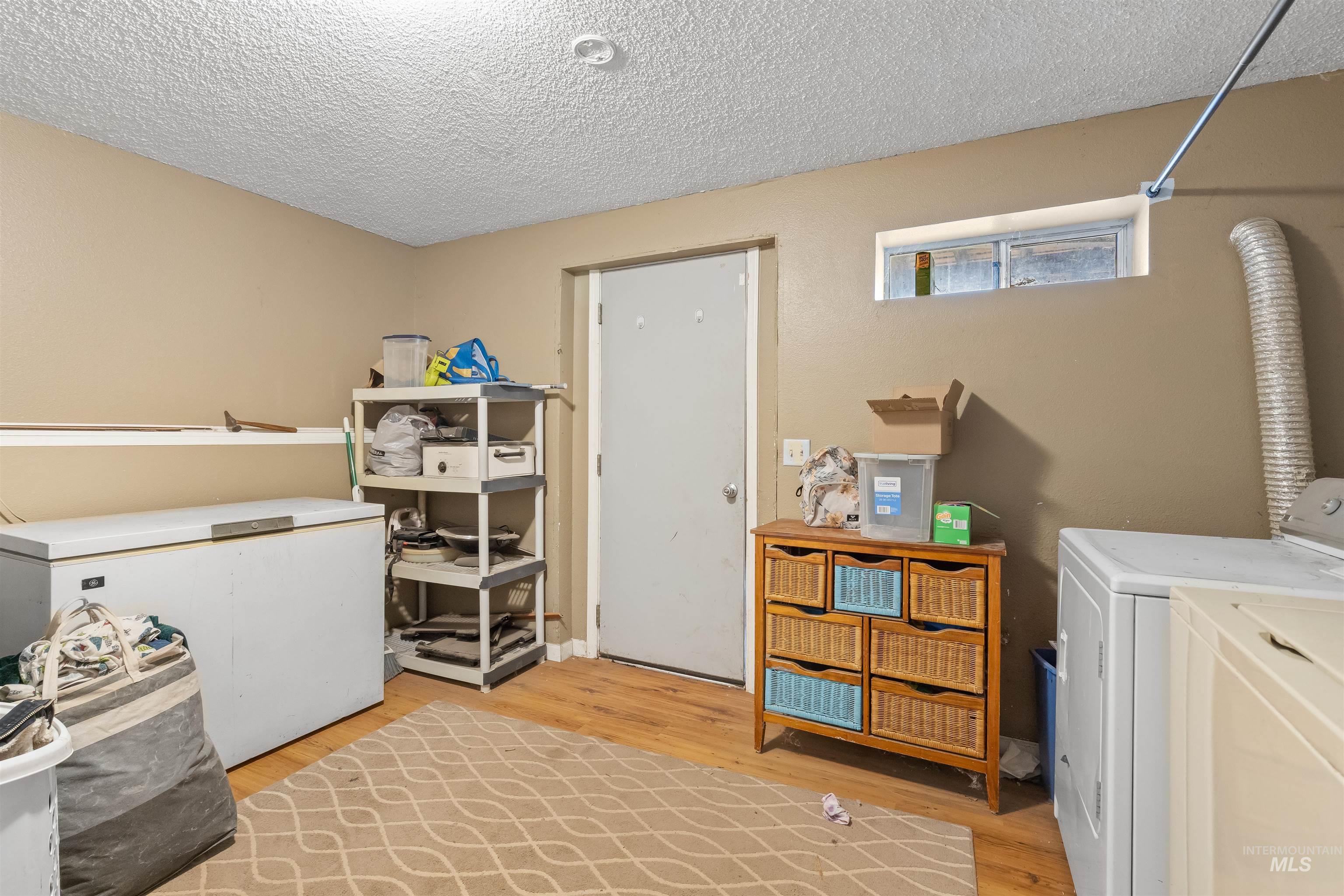 2460 State Street Pomeroy, WA 99347 - Photo 14 of 18 Utility space featuring wood-finish flooring, a painted concrete foundation wall, and a horizontal window