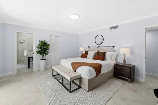 a living room with a table furniture a window and potted plants