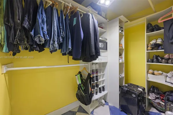 a view of walk in closet with clothes and shoes