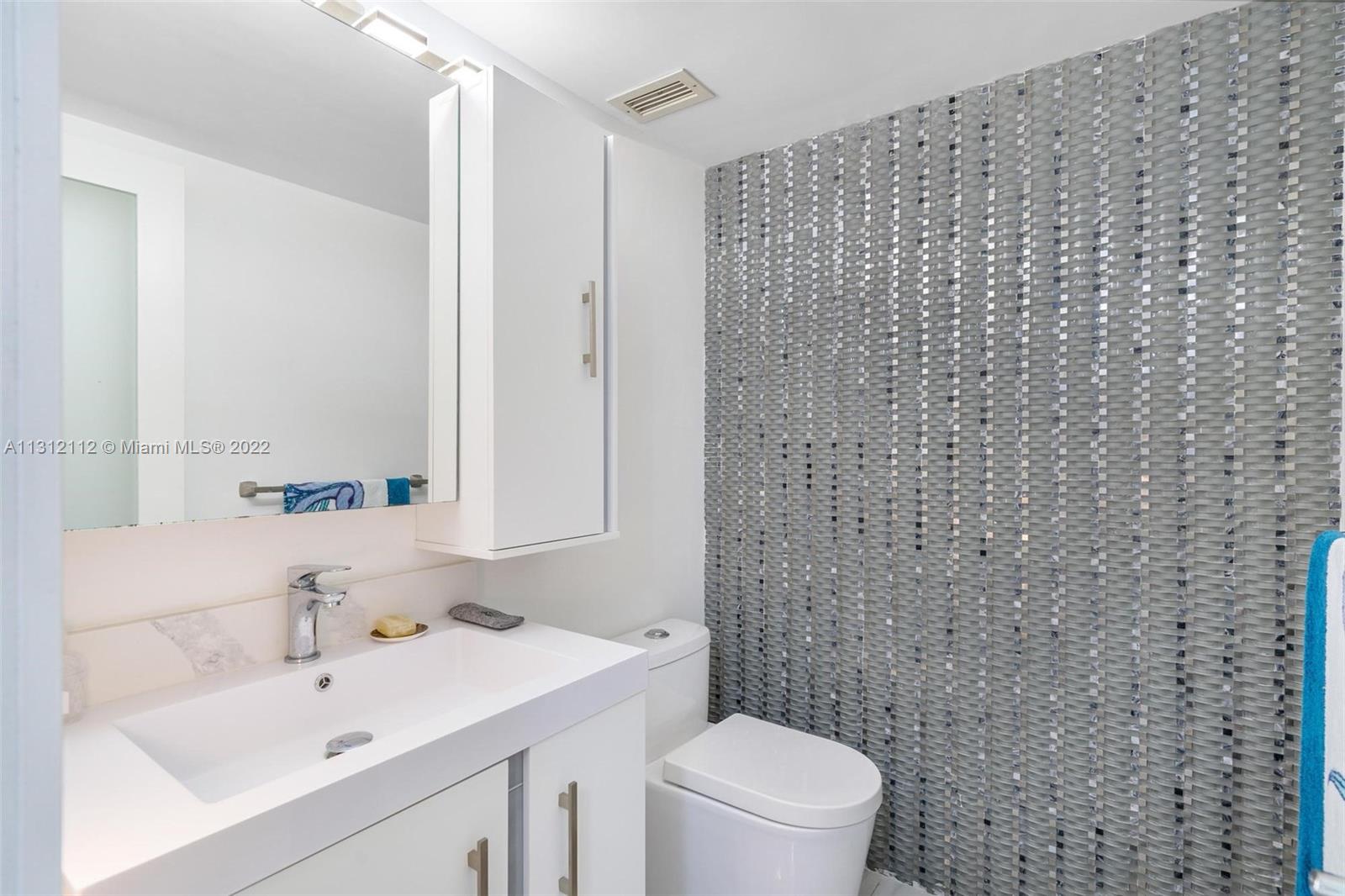 1450 Lincoln Road, Unit 403 Miami Beach, FL 33139 - Photo 17 of 21 a bathroom with a sink a toilet and a mirror