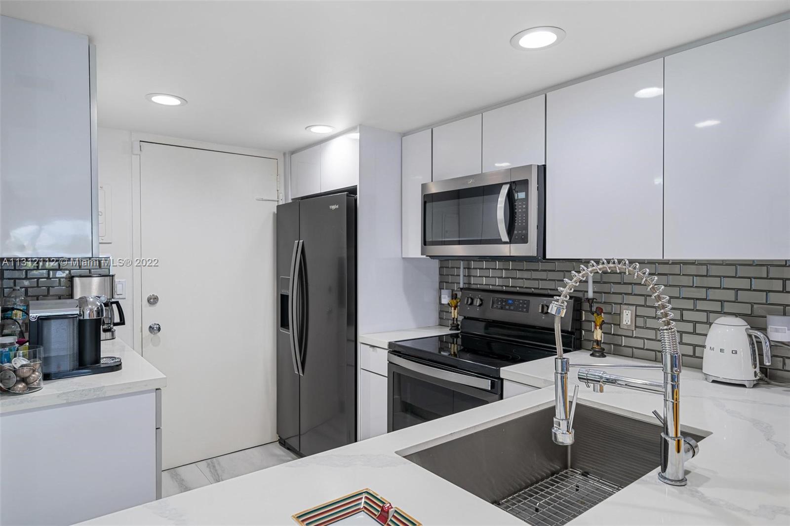 1450 Lincoln Road, Unit 403 Miami Beach, FL 33139 - Photo 9 of 21 a kitchen with a refrigerator stove and microwave