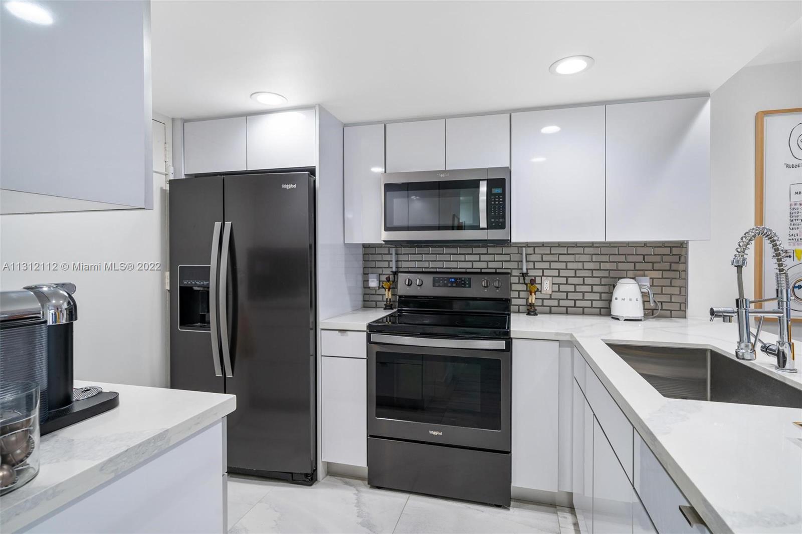 1450 Lincoln Road, Unit 403 Miami Beach, FL 33139 - Photo 10 of 21 a kitchen with a sink stove and refrigerator