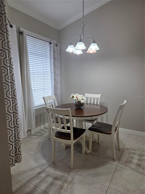 13703 Messina Loop, Unit 202 Bradenton, FL 34211 - Photo 11 of 42 a view of a dining room with furniture a chandelier and window