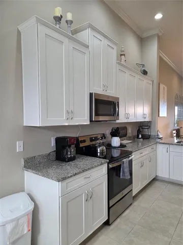a kitchen with white cabinets and appliances