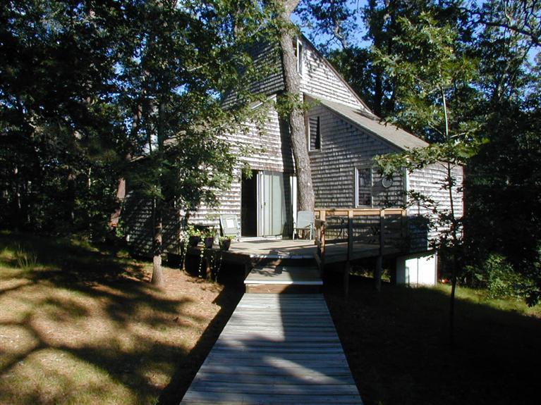 106 Cottontail Road, Unit A3 Wellfleet, MA 02667 - Photo 3 of 14 a view of house with backyard outdoor seating and trees in the background