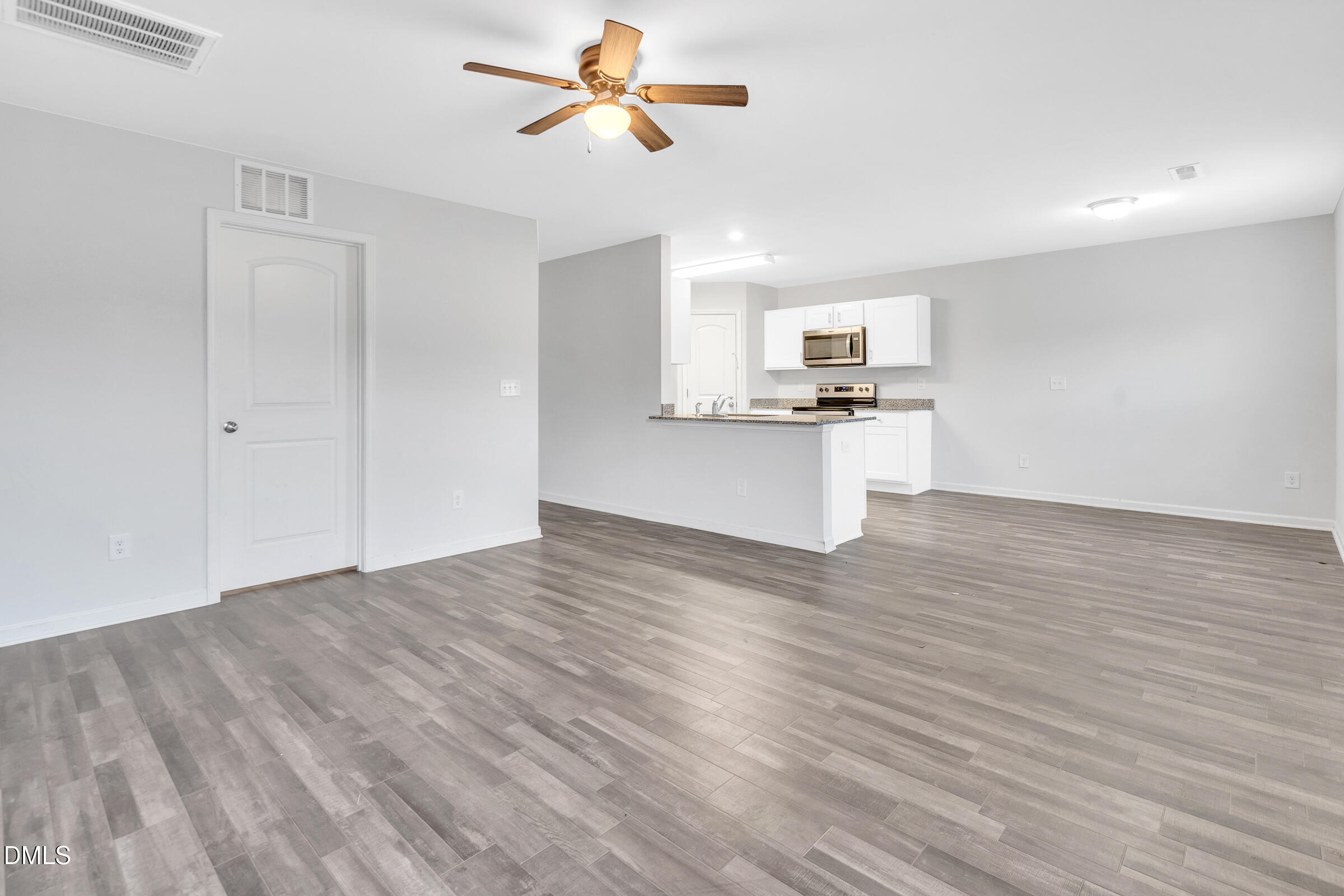 3146 Stoney Hill Church Road Bailey, NC 27807 - Photo 7 of 26 a view of a kitchen with wooden floor and a ceiling fan
