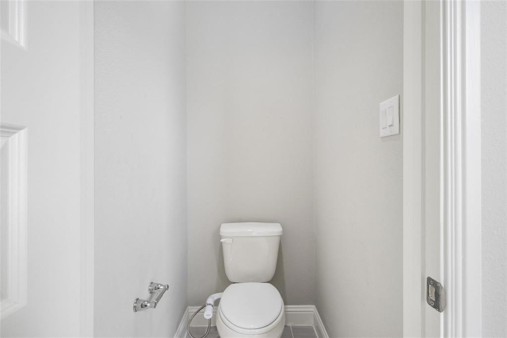7411 Joshua Road Frisco, TX 75033 - Photo 16 of 40 a white toilet sitting next to a white wall