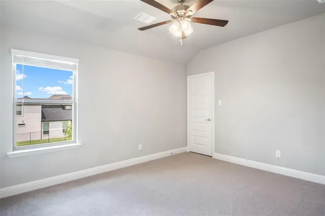 an empty room with a ceiling fan and window