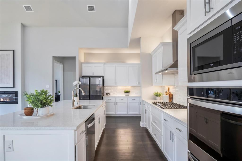 7411 Joshua Road Frisco, TX 75033 - Photo 9 of 40 a kitchen with a sink stove and microwave