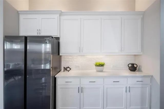 a kitchen with a refrigerator and cabinets