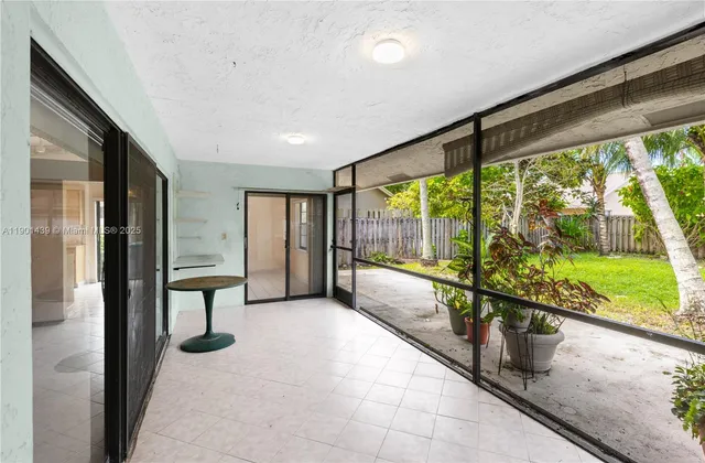 a view of a house with a yard and palm trees