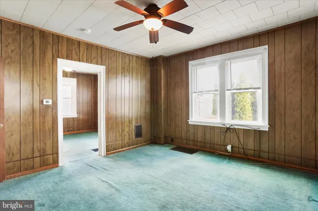 a view of a hallway with bathroom and wooden floor