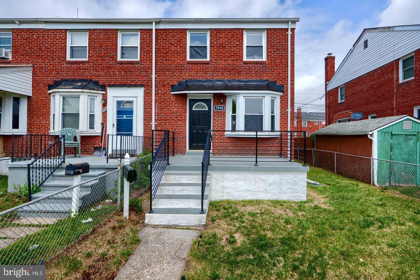 a front view of brick house with a yard