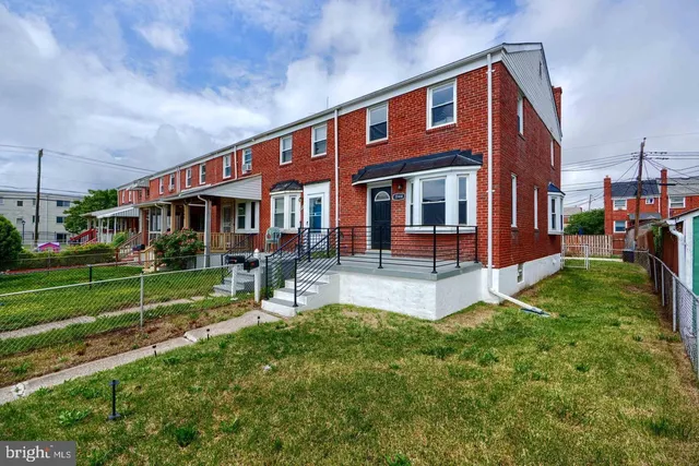 a view of a house with a yard deck and a large tree