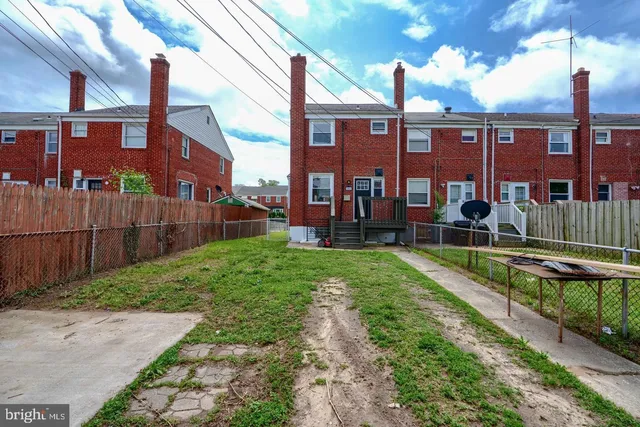 a view of a building with a yard and sitting area