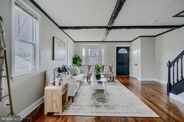 a living room with furniture wooden floor and white walls