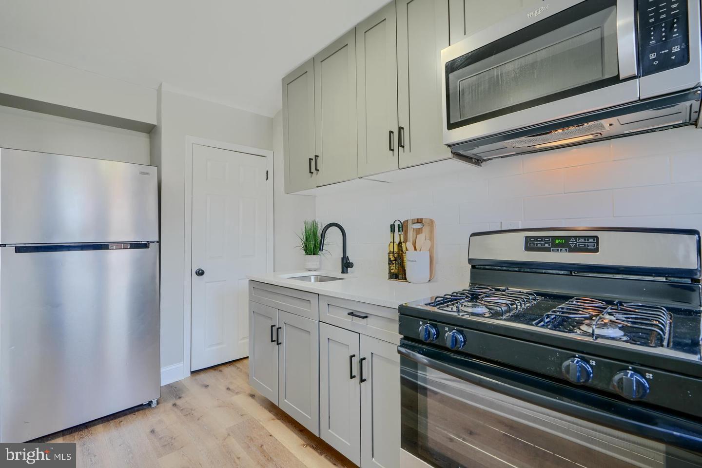 1944 Quentin Road Dundalk, MD 21222 - Photo 8 of 41 a kitchen with stainless steel appliances granite countertop a refrigerator stove and white cabinets