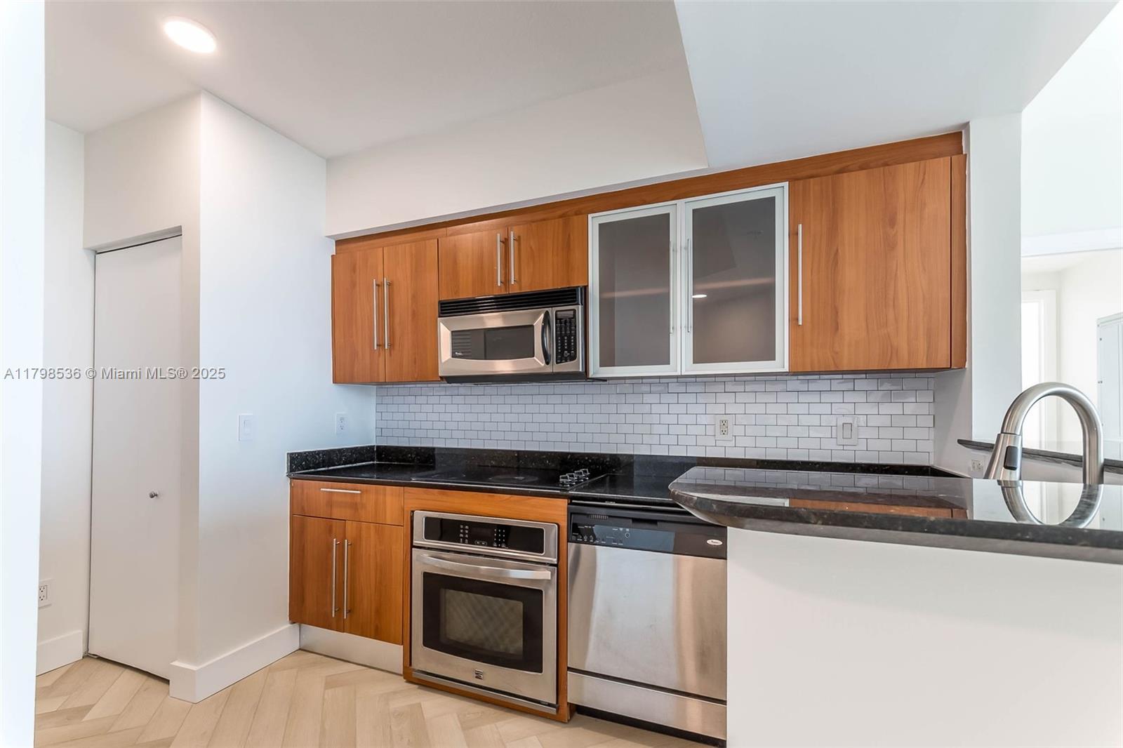 335 South Biscayne Boulevard, Unit 1012 Miami, FL 33131 - Photo 13 of 14 a kitchen with stainless steel appliances granite countertop a sink and a stove top oven