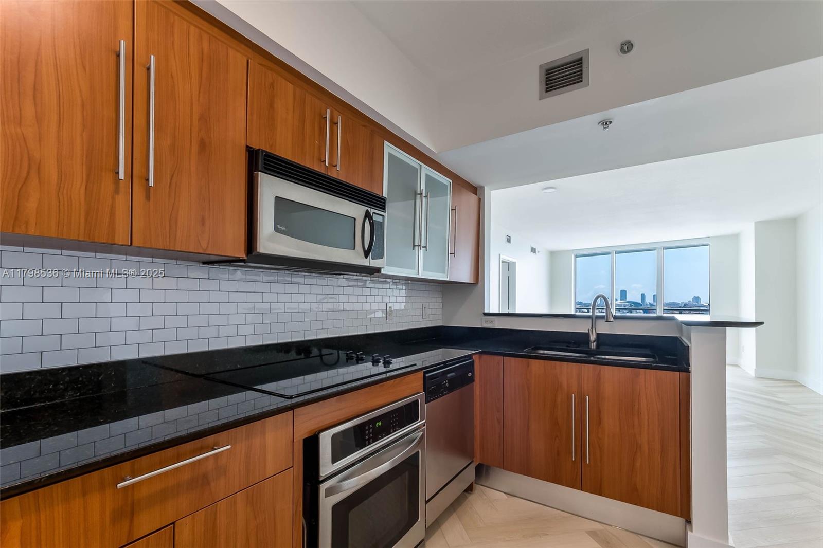 335 South Biscayne Boulevard, Unit 1012 Miami, FL 33131 - Photo 5 of 14 a kitchen with granite countertop stainless steel appliances a sink a stove top oven and cabinets