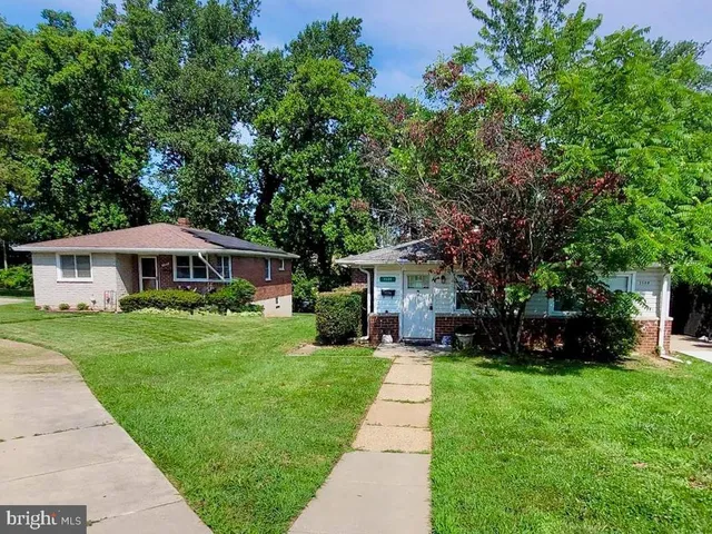a front view of a house with a yard and trees