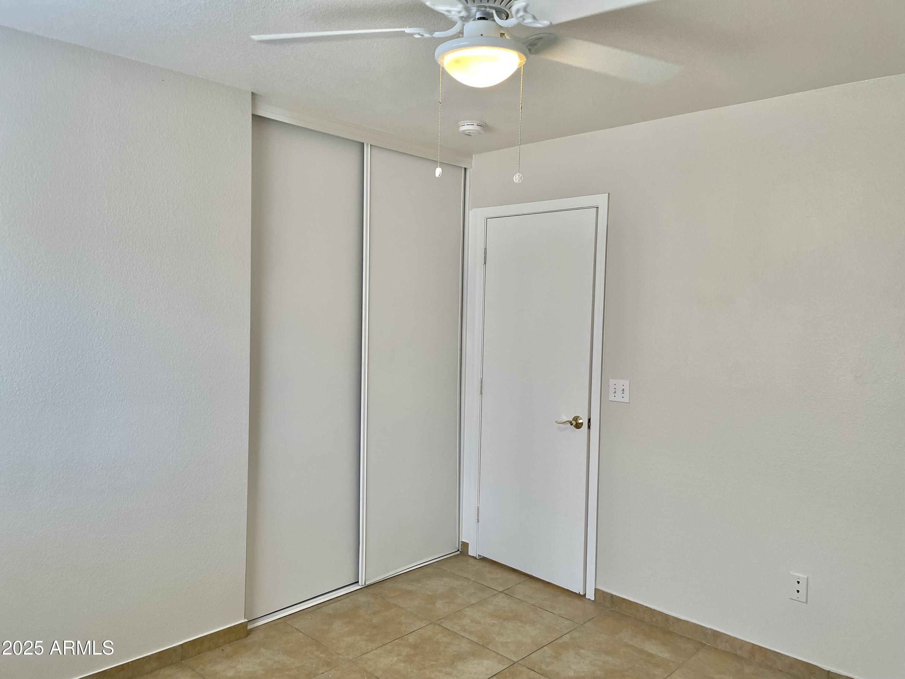 1002 East Arabian Drive Gilbert, AZ 85296 - Photo 20 of 23 an empty room with a chandelier fan and closet