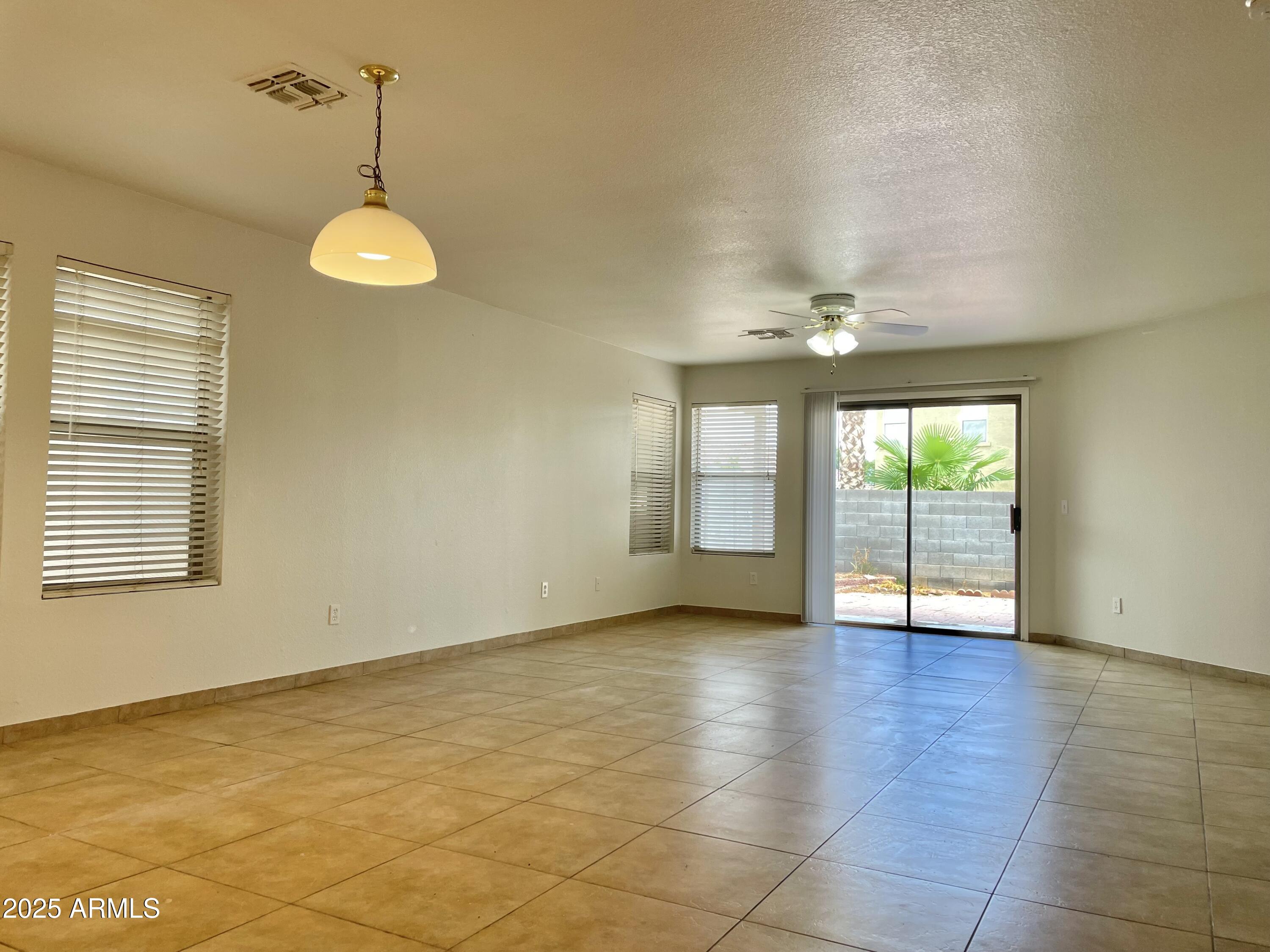 1002 East Arabian Drive Gilbert, AZ 85296 - Photo 6 of 23 a view of an empty room with a window and wooden floor