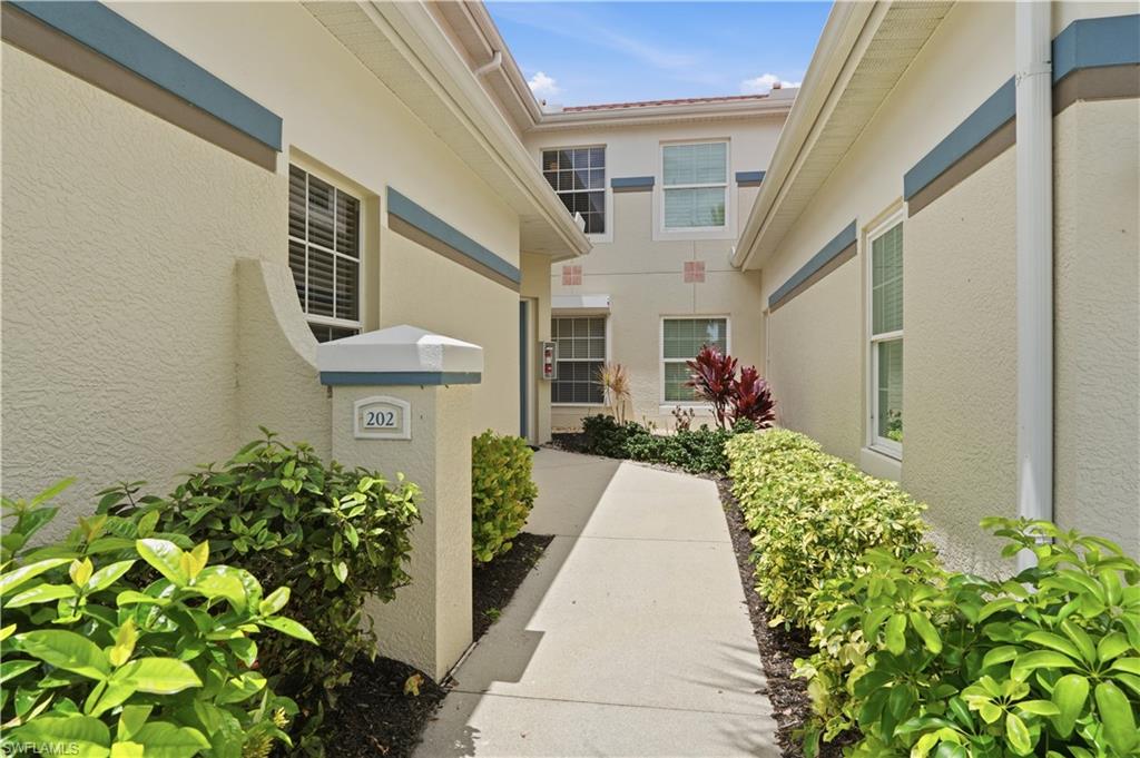 10871 Crooked River Road, Unit 202 Estero, FL 34135 - Photo 32 of 46 a front view of a house with a yard