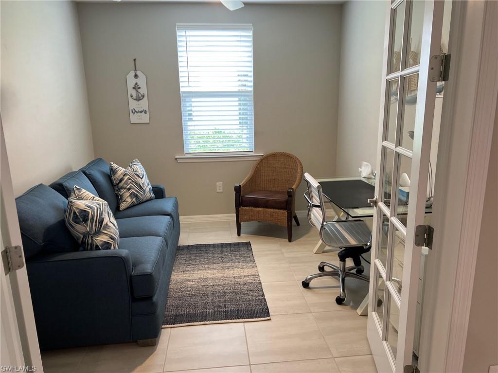 14827 Edgewater Circle Naples, FL 34114 - Photo 19 of 32 a living room with furniture and a window