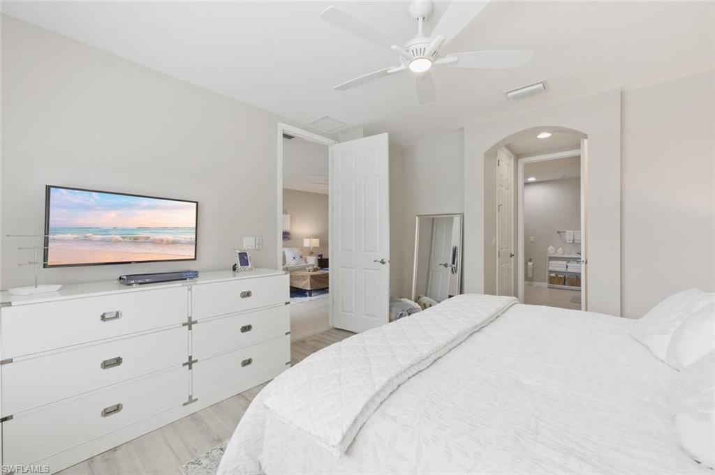 14827 Edgewater Circle Naples, FL 34114 - Photo 22 of 49 a bedroom with a bed and a flat screen tv