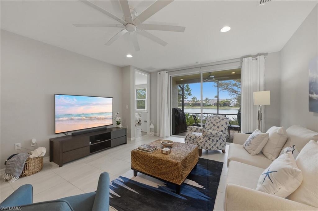 14827 Edgewater Circle Naples, FL 34114 - Photo 6 of 49 a living room with furniture and a flat screen tv