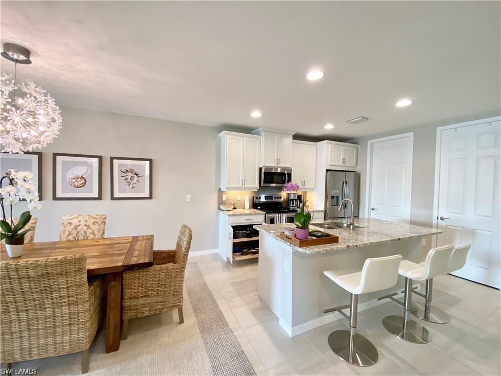 14827 Edgewater Circle Naples, FL 34114 - Photo 8 of 32 a living room with stainless steel appliances kitchen island granite countertop furniture a dining table and chairs