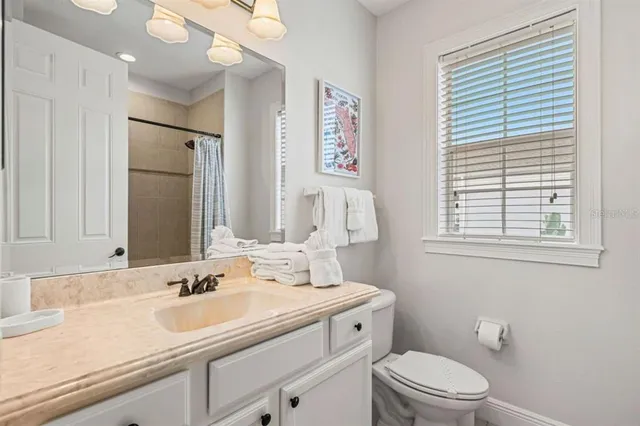 a bathroom with a granite countertop sink toilet a large mirror and shower