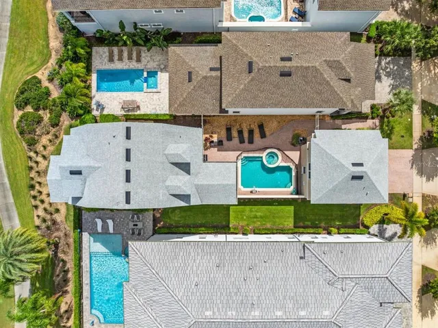 an aerial view of a house with a yard and a large tree