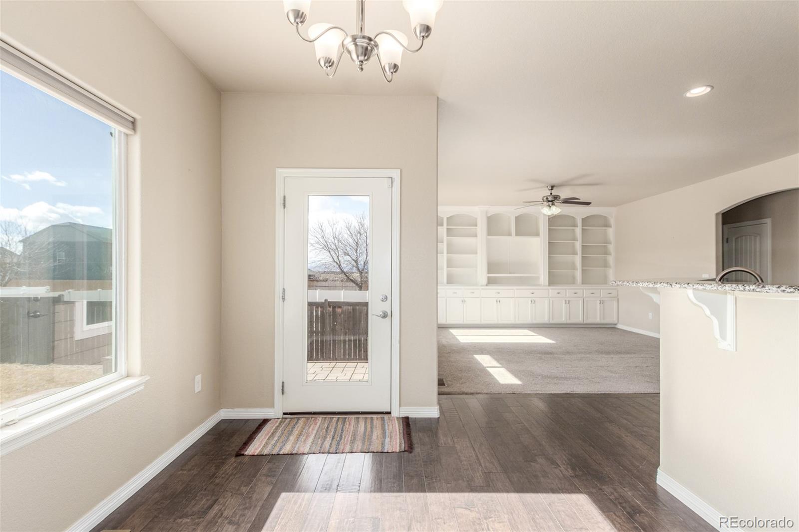 6654 12th Street Frederick, CO 80530 - Photo 12 of 50 a view of a livingroom with wooden floor and a kitchen space