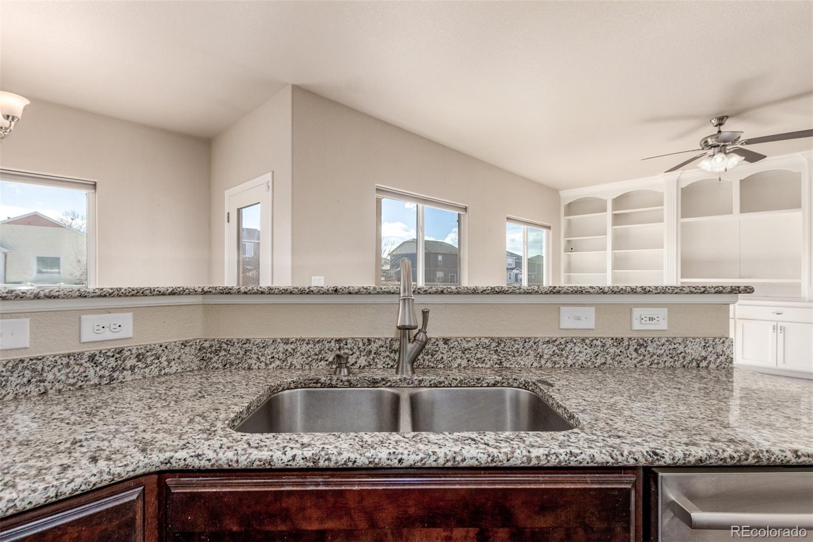 6654 12th Street Frederick, CO 80530 - Photo 14 of 50 a kitchen with granite countertop a sink and a wooden cabinets