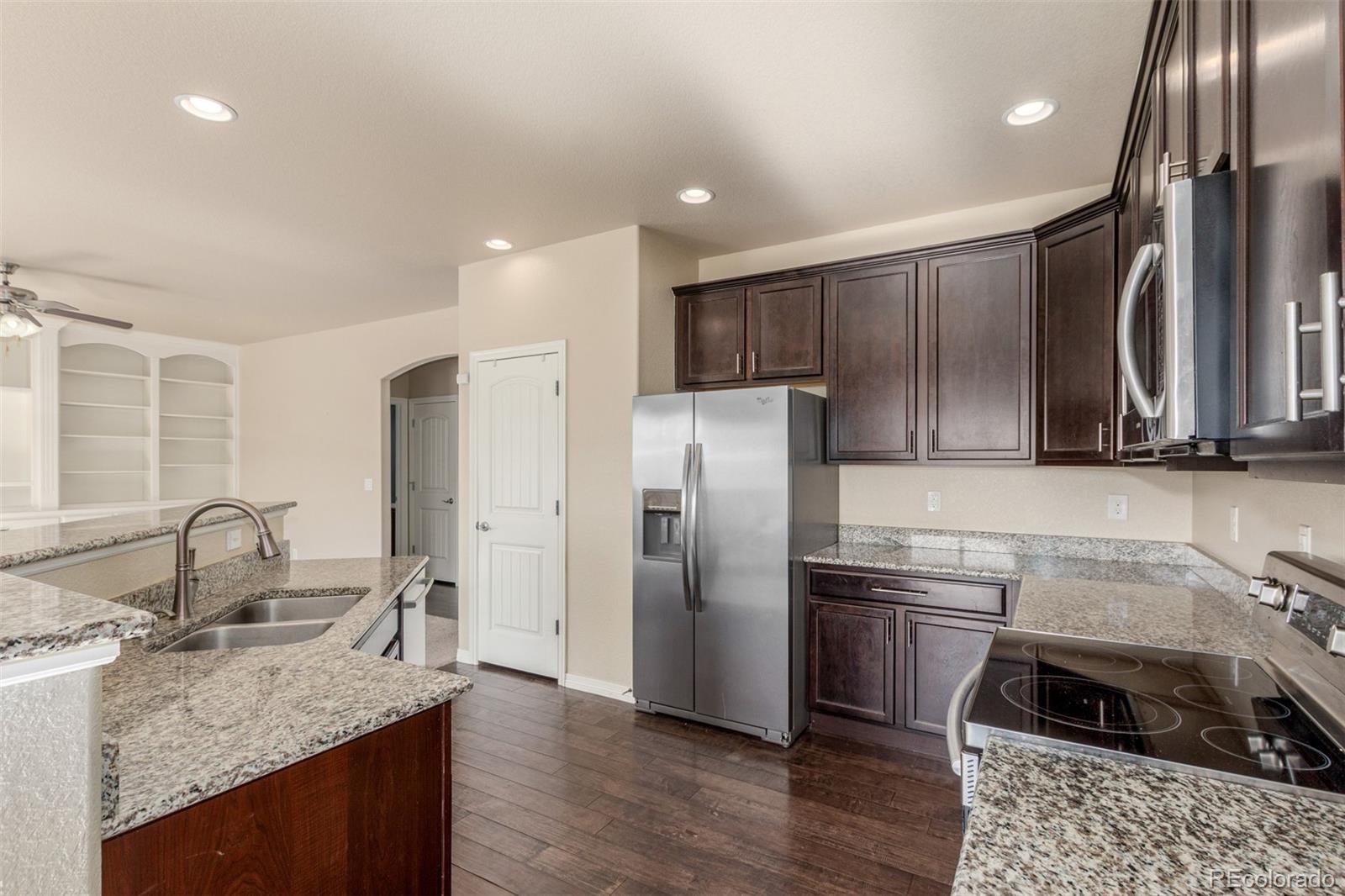 6654 12th Street Frederick, CO 80530 - Photo 15 of 50 a kitchen with stainless steel appliances granite countertop a sink stove and refrigerator