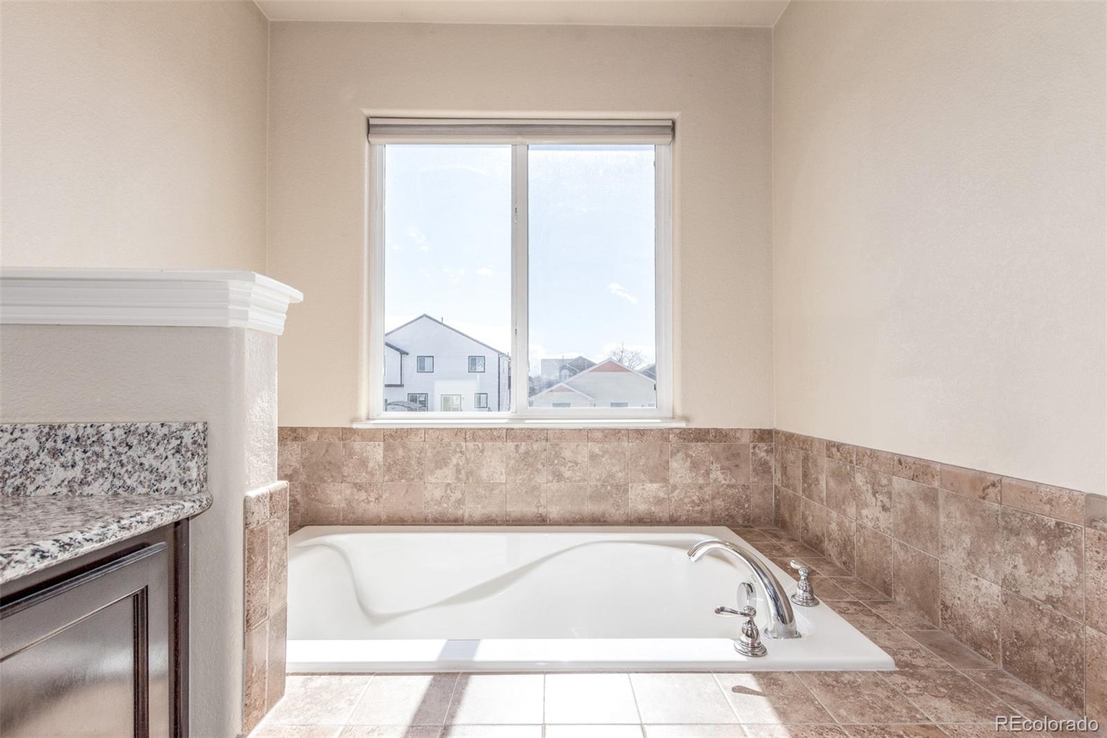 6654 12th Street Frederick, CO 80530 - Photo 21 of 50 a bathroom with a bathtub and window