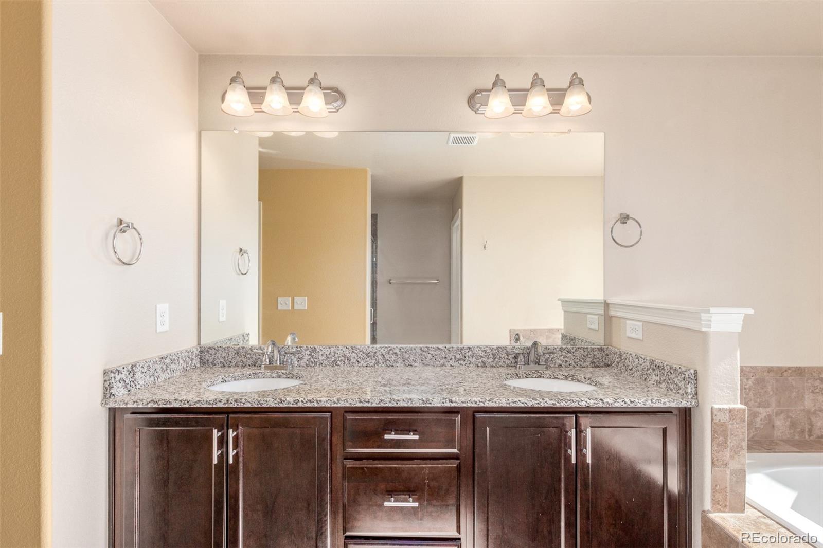 6654 12th Street Frederick, CO 80530 - Photo 22 of 50 a bathroom with a granite countertop sink and a mirror
