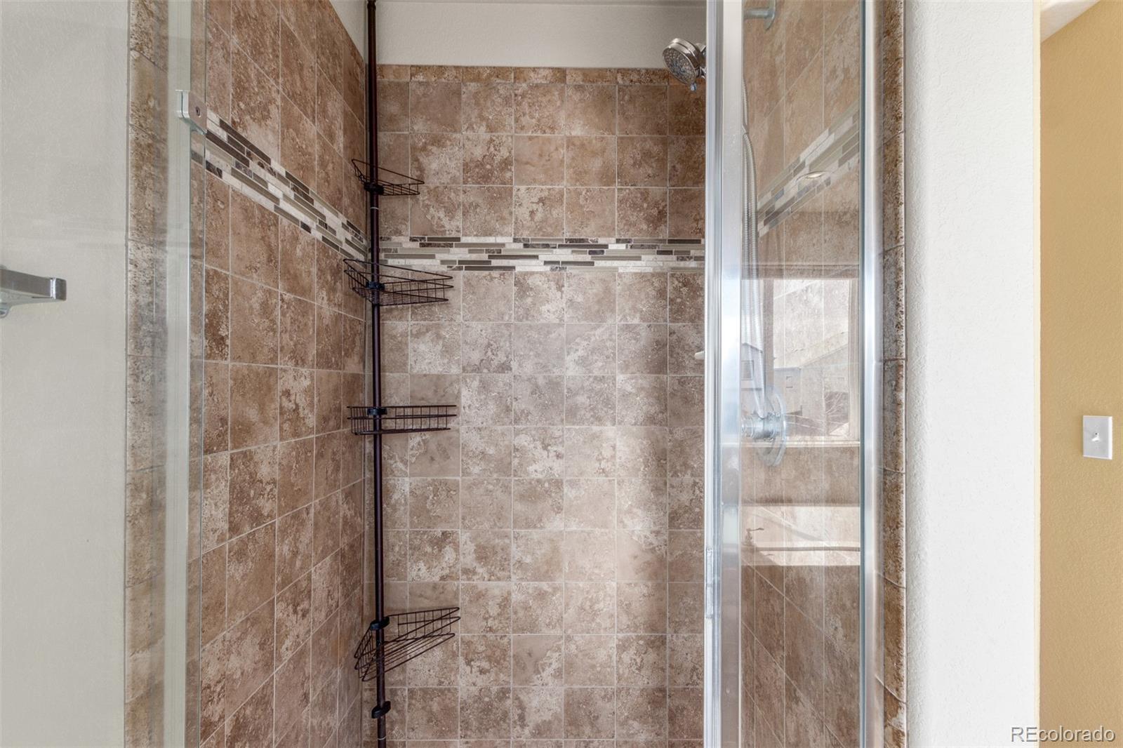 6654 12th Street Frederick, CO 80530 - Photo 23 of 50 a bathroom with a glass shower door