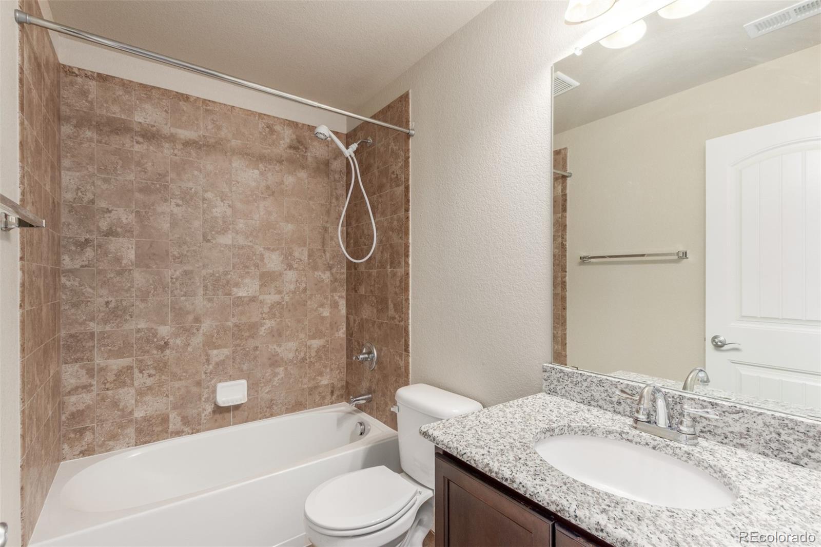 6654 12th Street Frederick, CO 80530 - Photo 40 of 50 a bathroom with a granite countertop sink toilet and shower