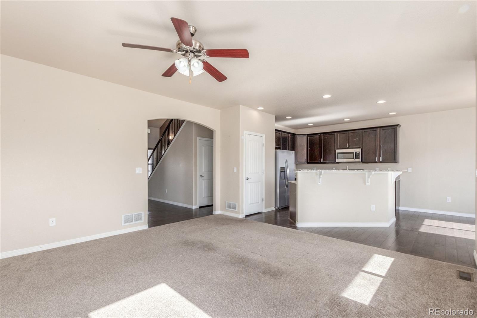 6654 12th Street Frederick, CO 80530 - Photo 10 of 50 a view of a kitchen with a microwave and a ceiling fan