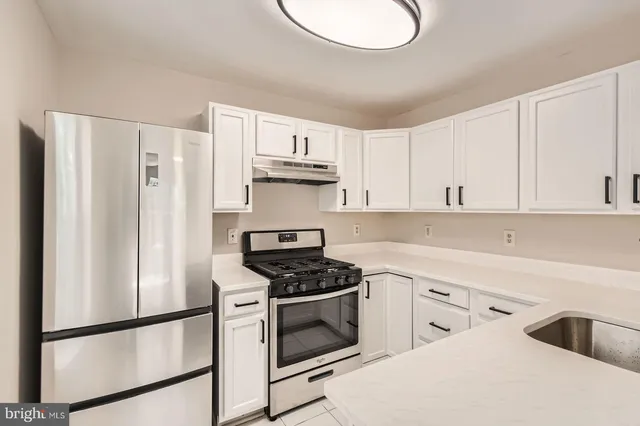 a kitchen with white cabinets and white appliances