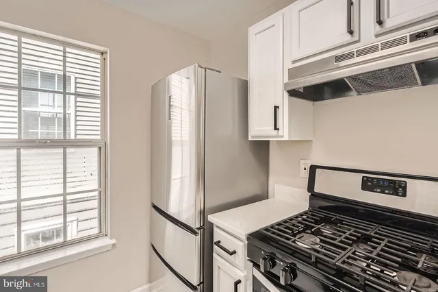 a stove top oven sitting inside of a kitchen