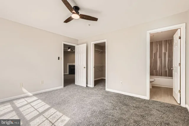 a bathroom with a granite countertop bathtub sink vanity mirror and toilet