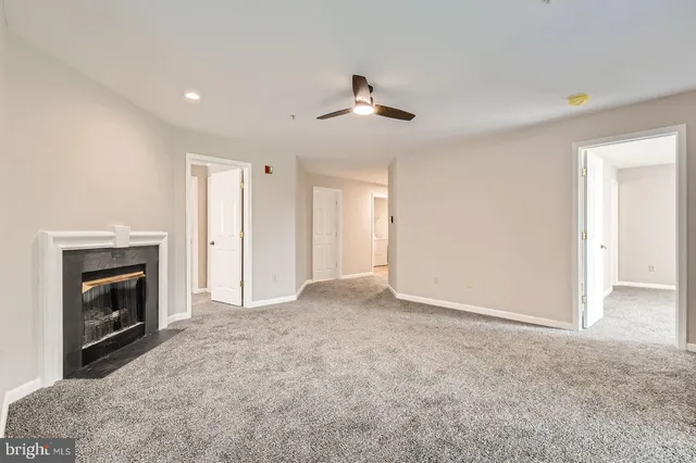a view of empty room with fireplace and fan
