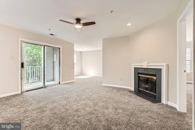 a view of an empty room with a fireplace and a window