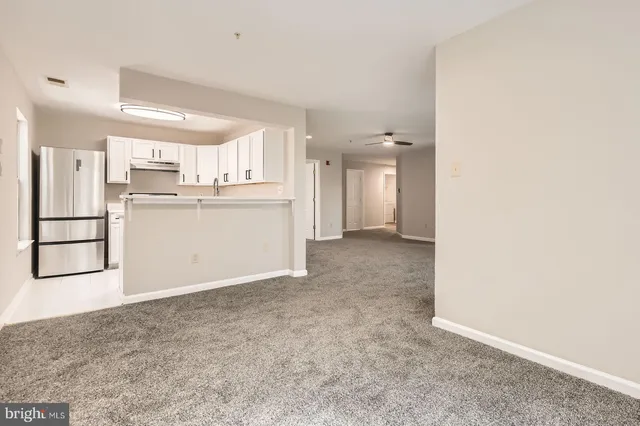 a view of a kitchen with refrigerator and cabinets