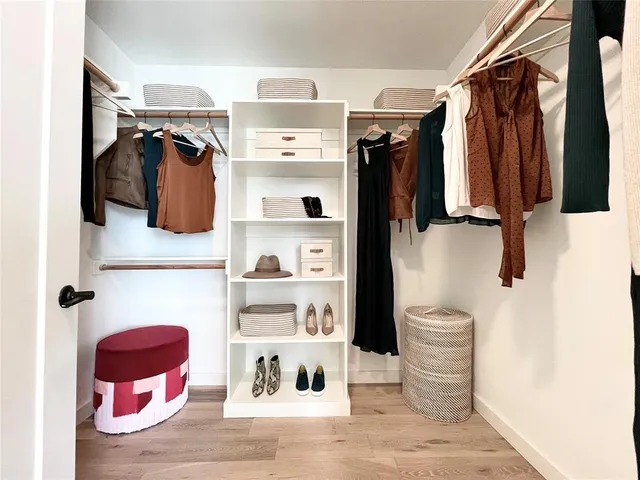 a view of walk in closet with clothes and shoes
