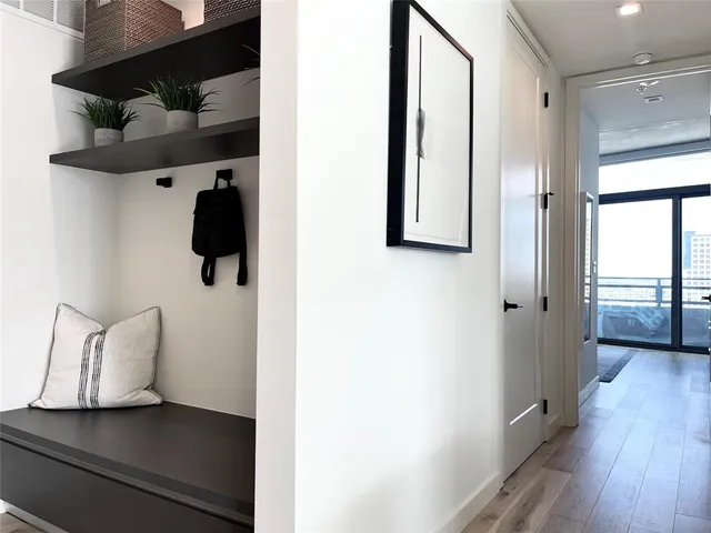 a view of a hallway with wooden floor and cabinet
