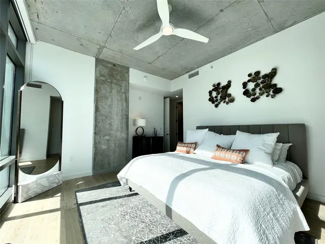 a bedroom with a large bed and a mirror on dresser